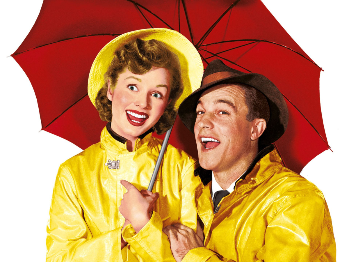 Promotional image for Singin' In The Rain showing a man and a woman in yellow raincoats under a red umbrella