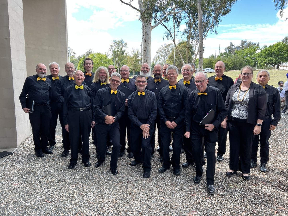 A group of people in black clothes with yellow bow-ties