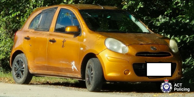 An orange car with the front number plate covered