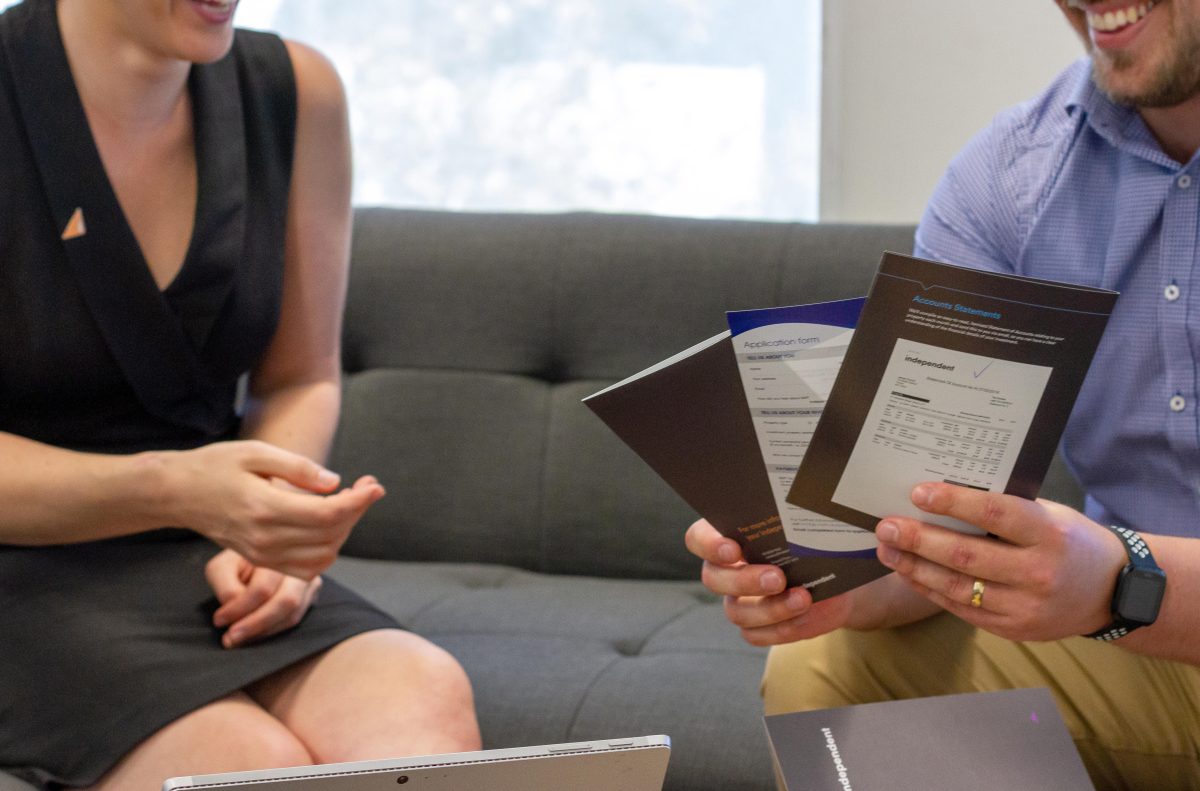 Man hands woman some Independent Property Group brochures