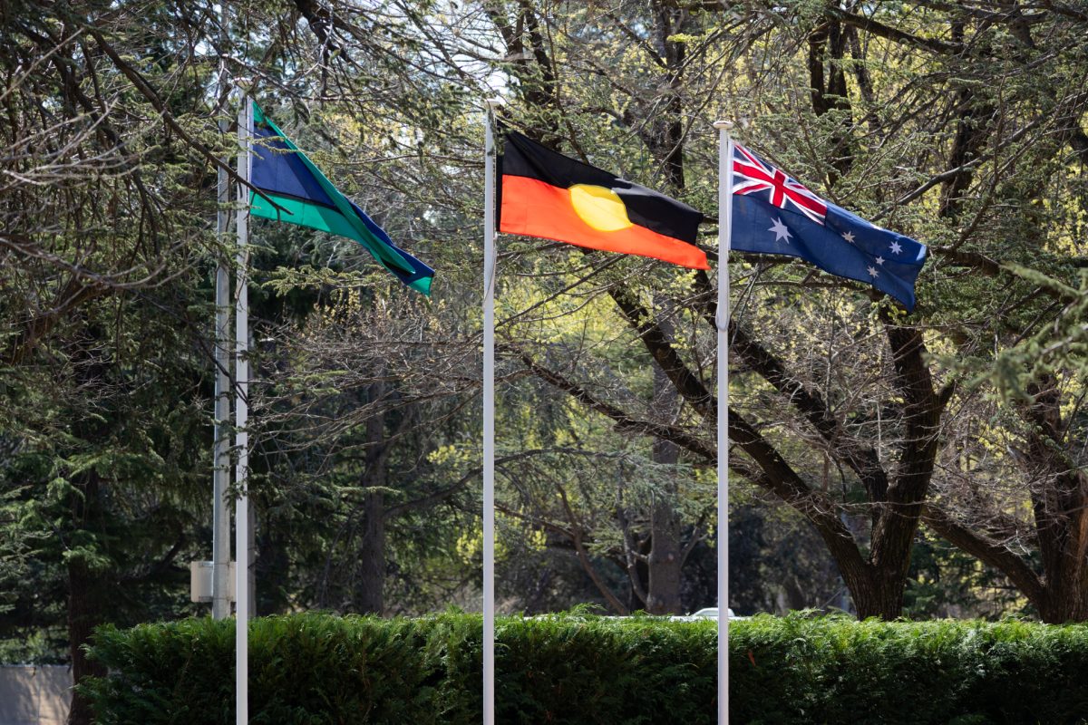 Three flagpoles with Torres Strait Islander flag, Australian Aboriginal flag and Australian national flag