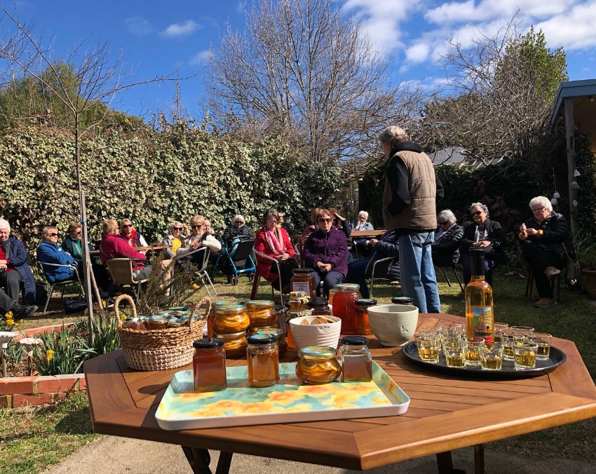 Tasting plate of honey and mead with group outdoors