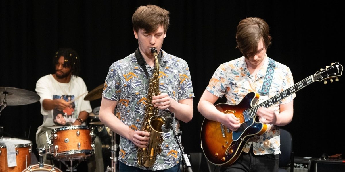 Three male musicians playing their instruments