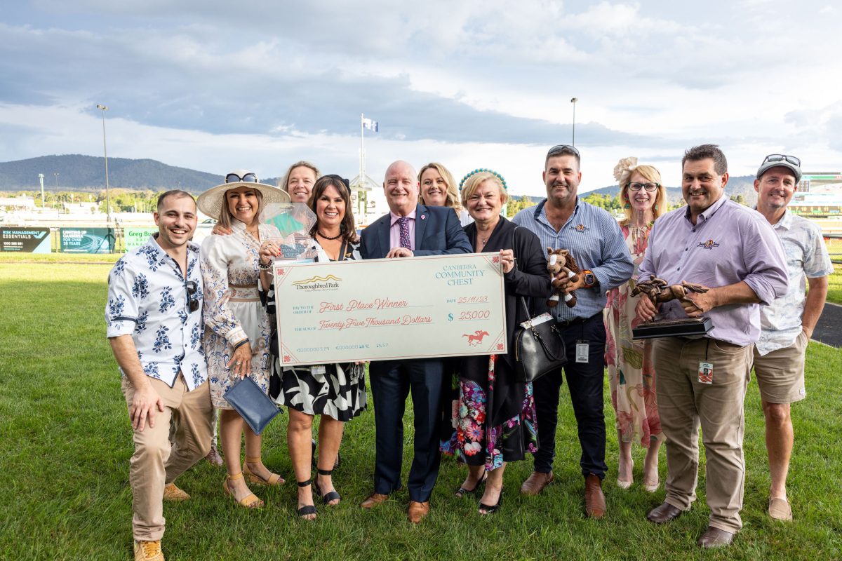 Group of people holding a novelty cheque on race grounds at Thoroughbred Park