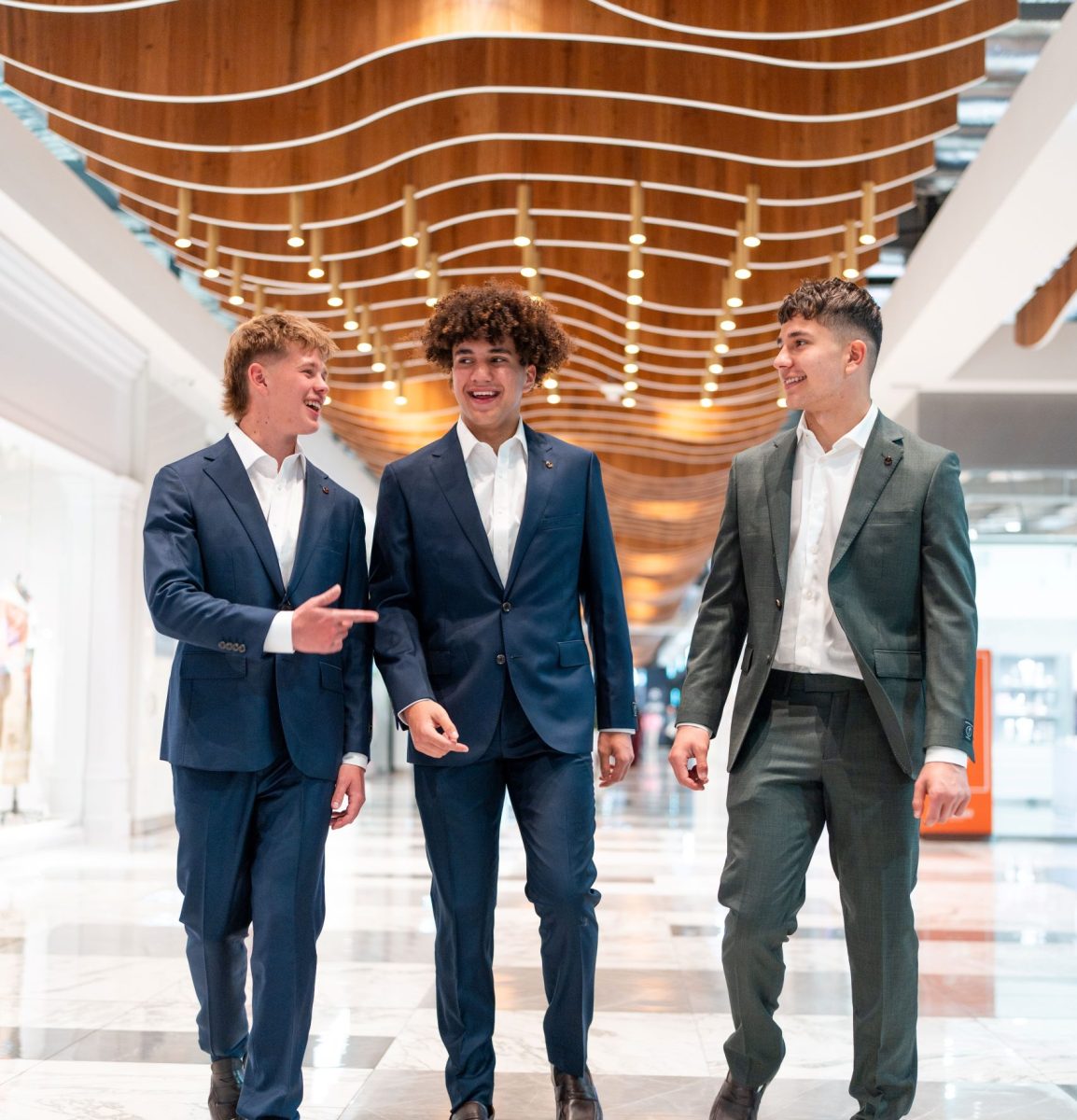 Three young men walking in suits