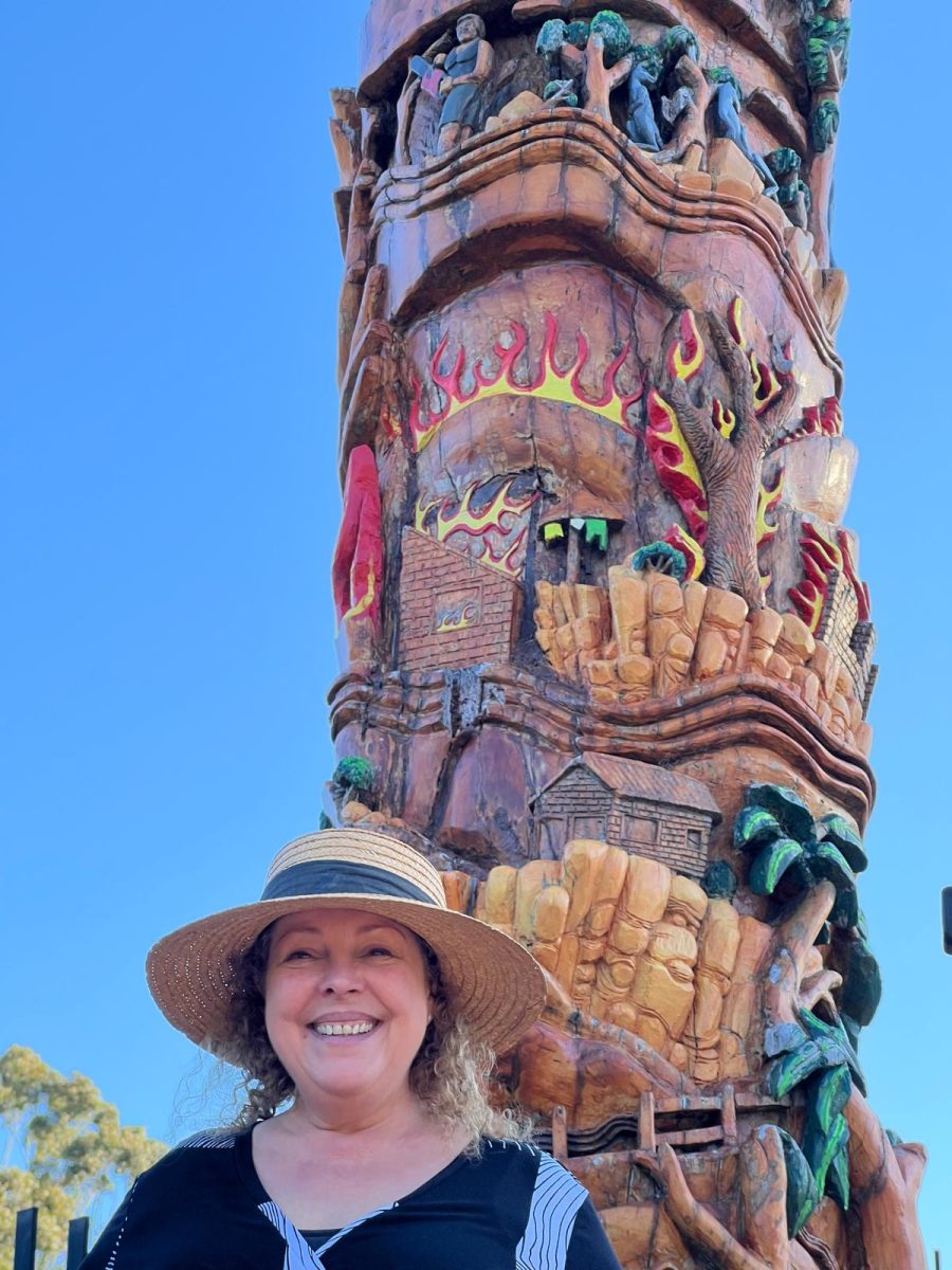 Lady standing in front of a tree sculpture