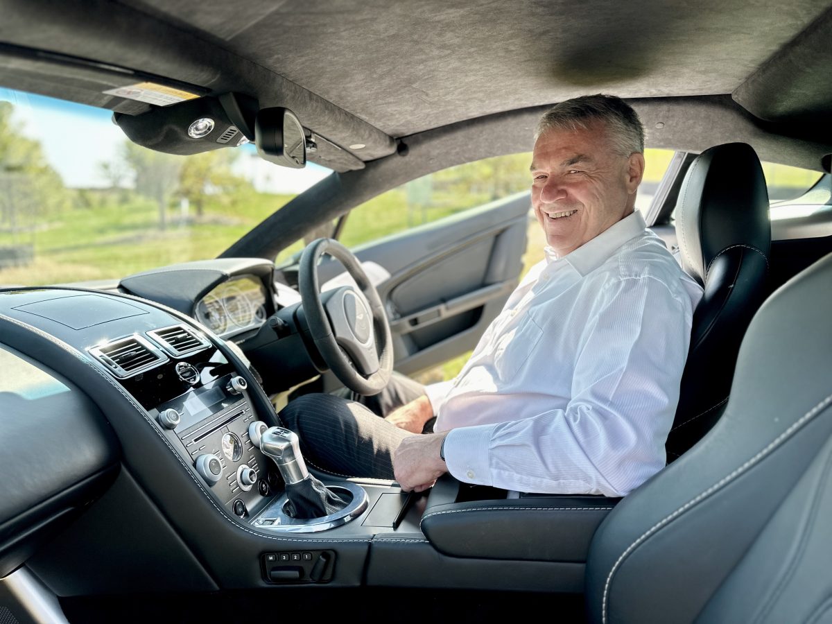 Man sitting in driver's seat of sports car