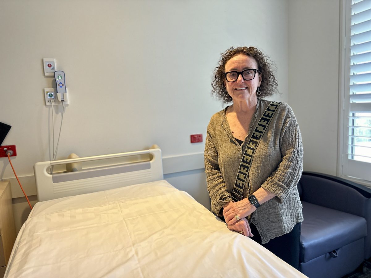 Nurse standing by hospital bed