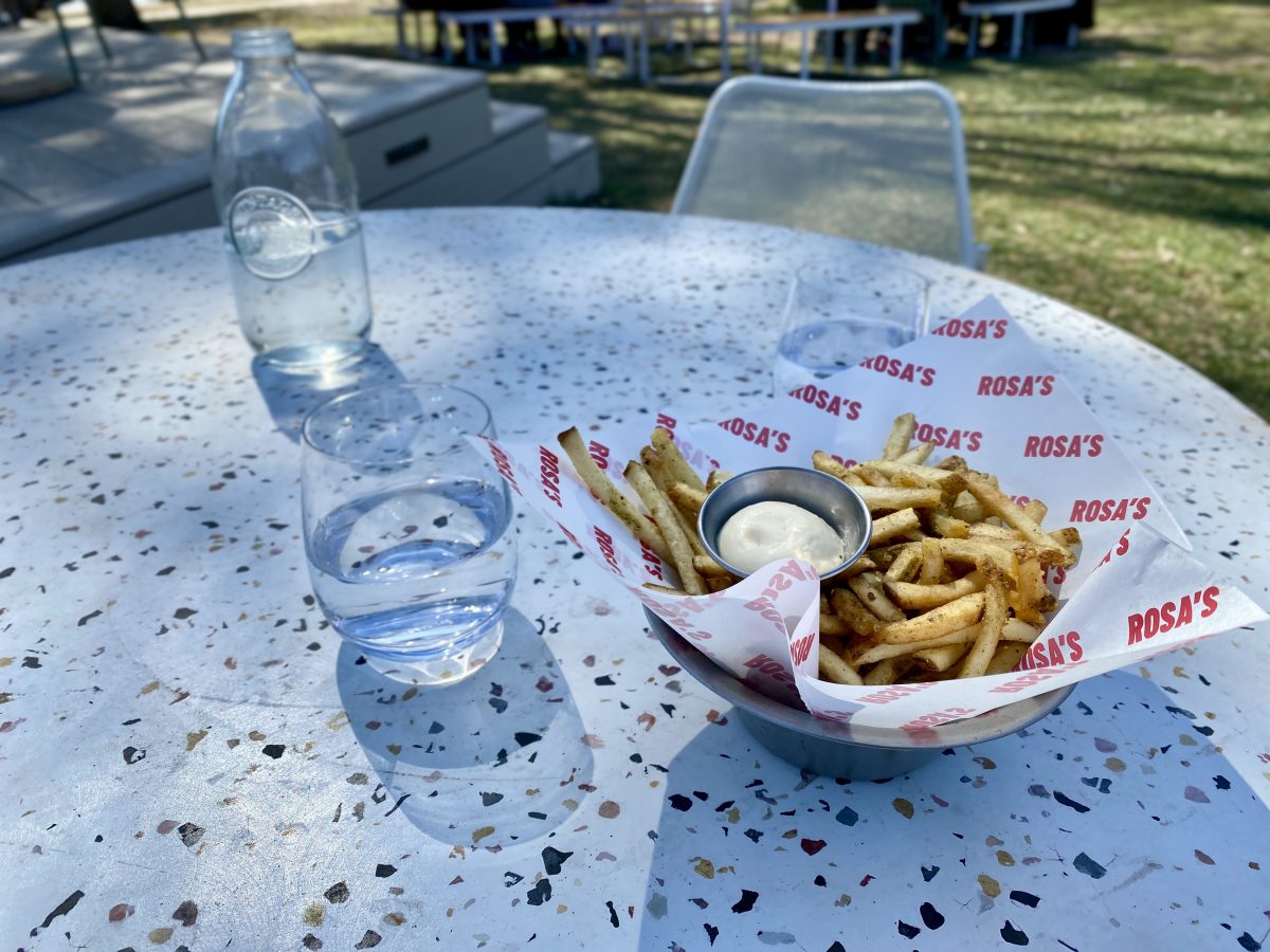 Bowl of fries with Rosa's branded paper on a terrazzo-patterned table.