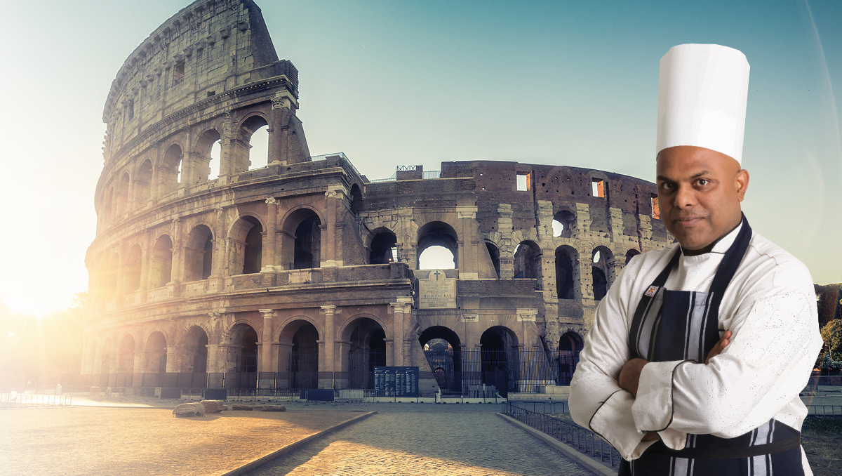 A man in a chef's uniform and hat next to the Colosseum