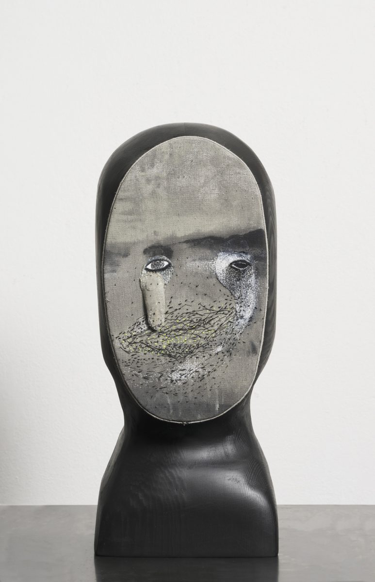 A sculptural head with a landscape face