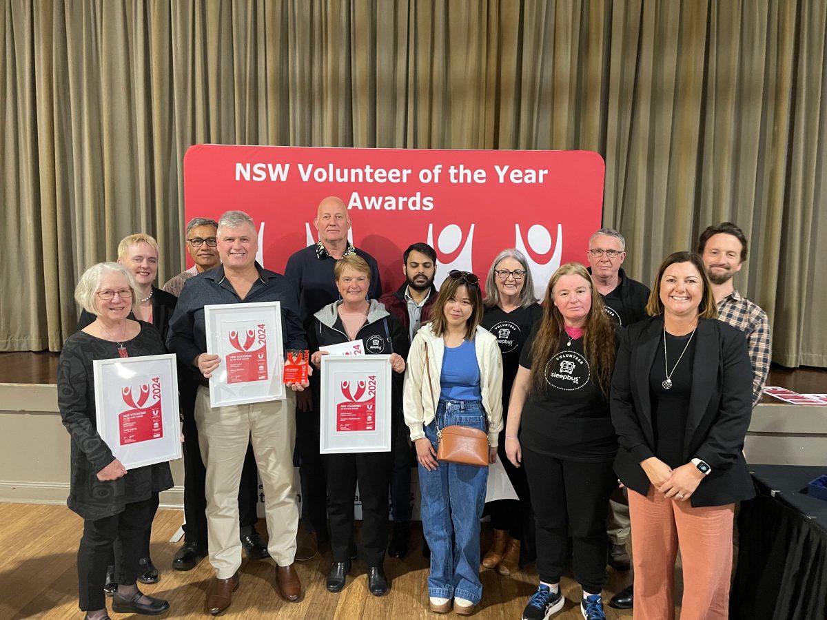 Group of people in front of sign saying NSW Volunteer of the Year Awards.