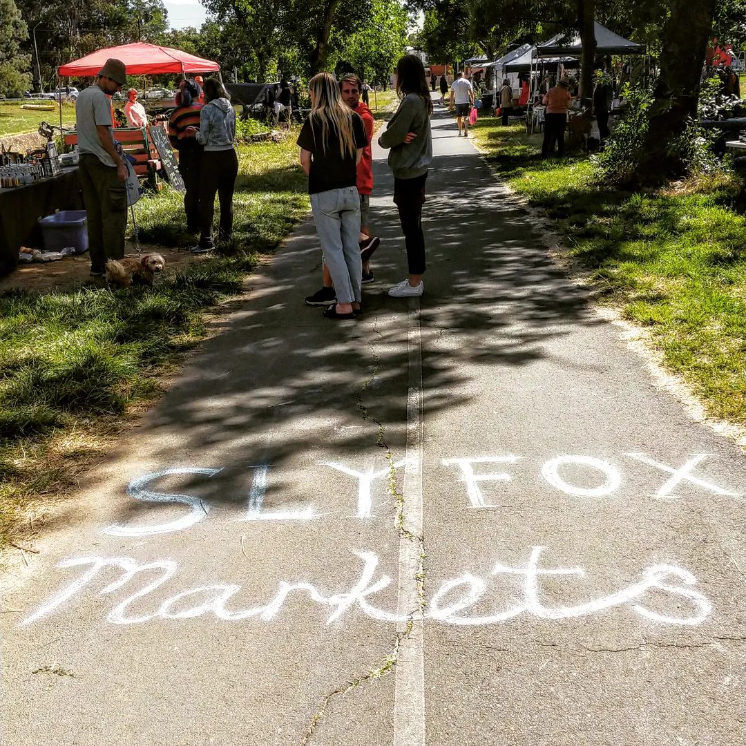 Bike path with chalk writing that says 'Sly Fox markets'