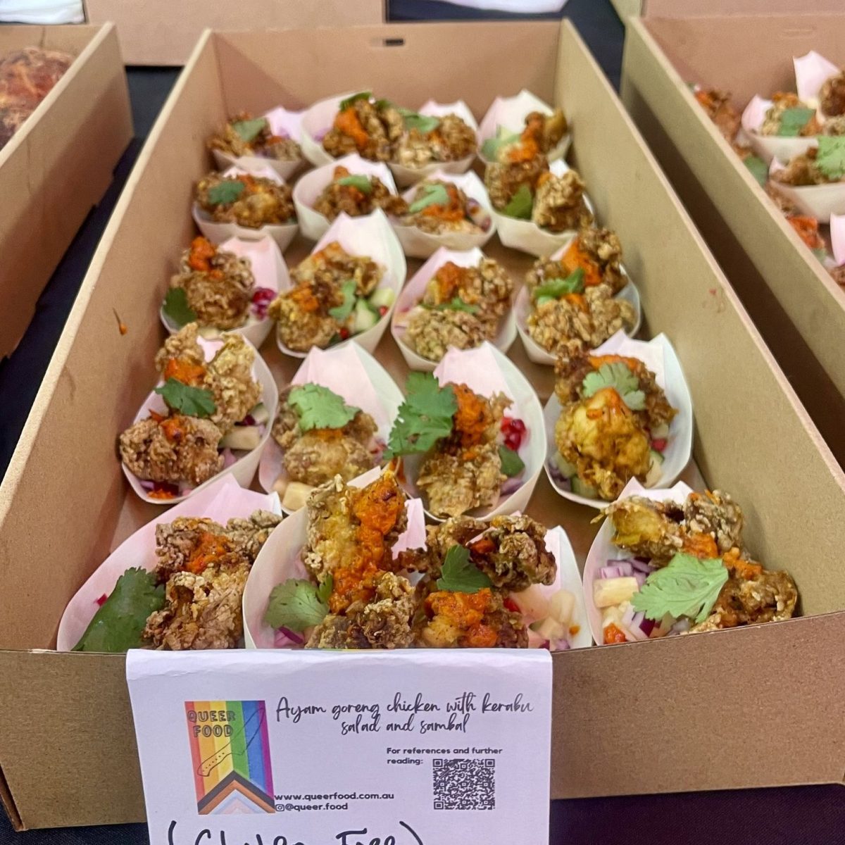 A tray of small bamboo containers with chicken salad.