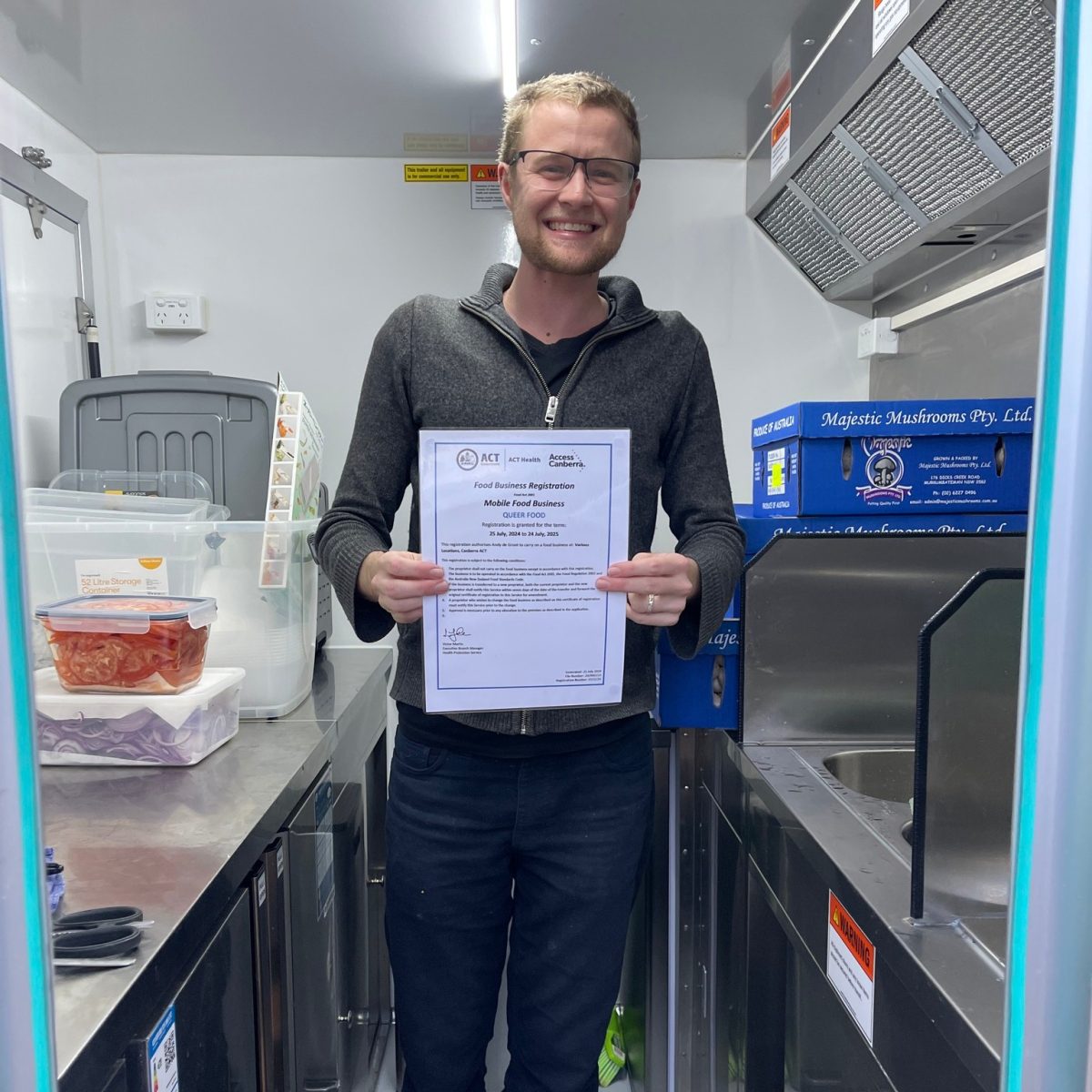 Man holds a certificate inside a catering van