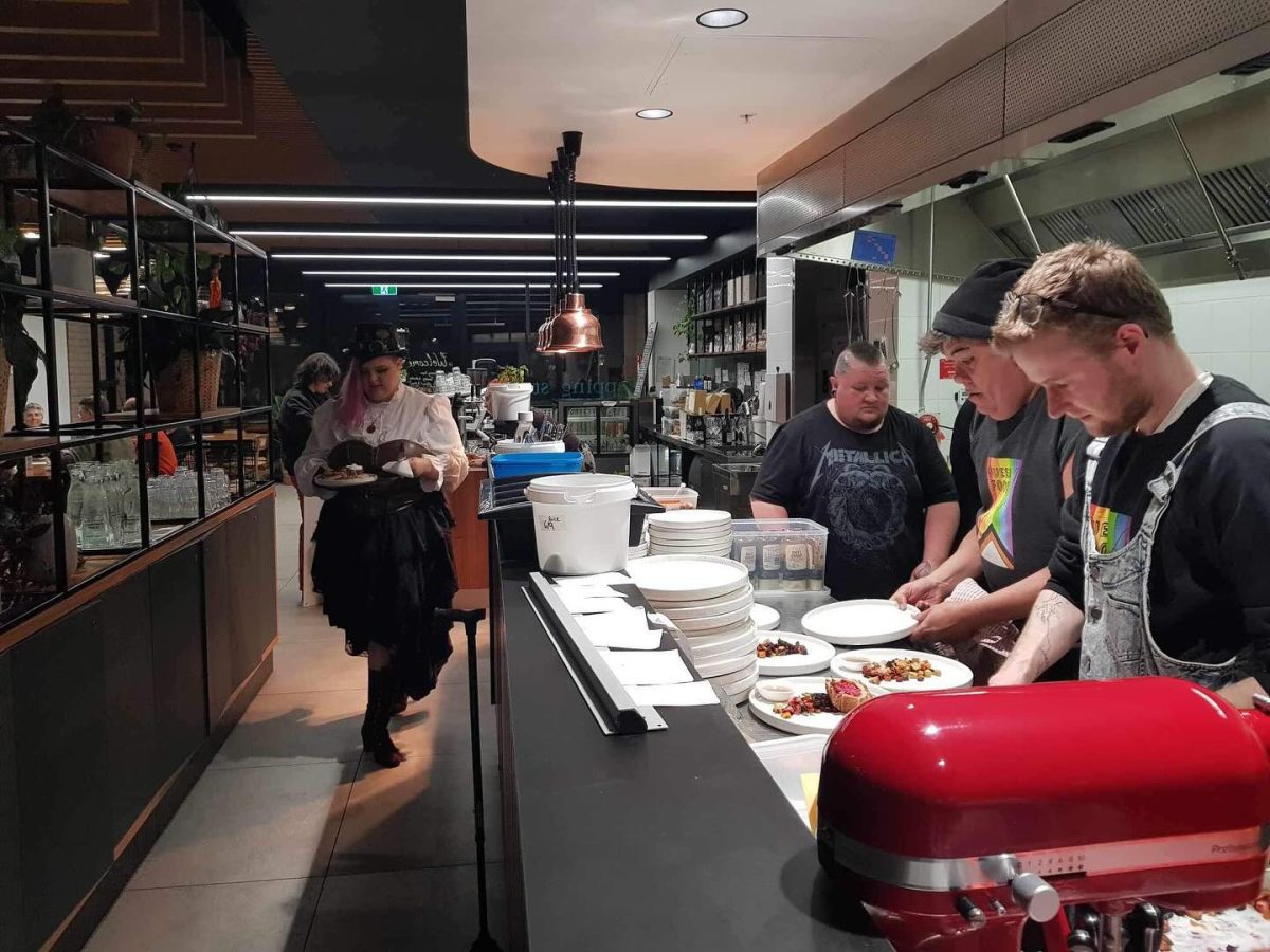 A diverse team working in the kitchen at an event.