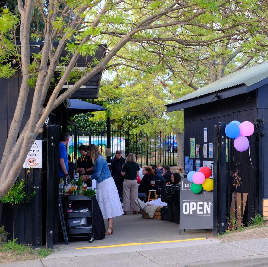 Balloons and an open sign outside a community cafe.