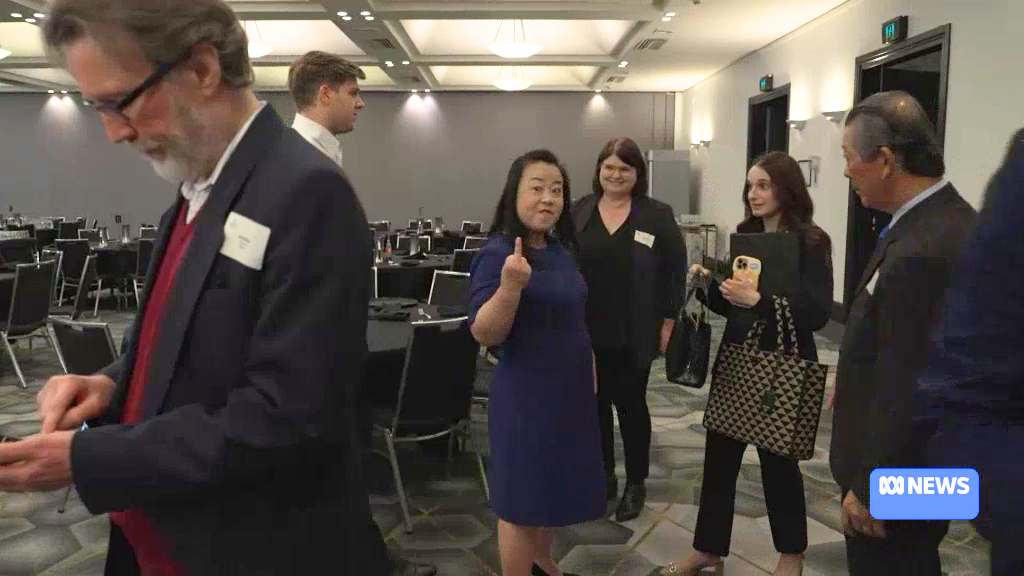 Elizabeth Lee using her finger to make a gesture at a journalist 