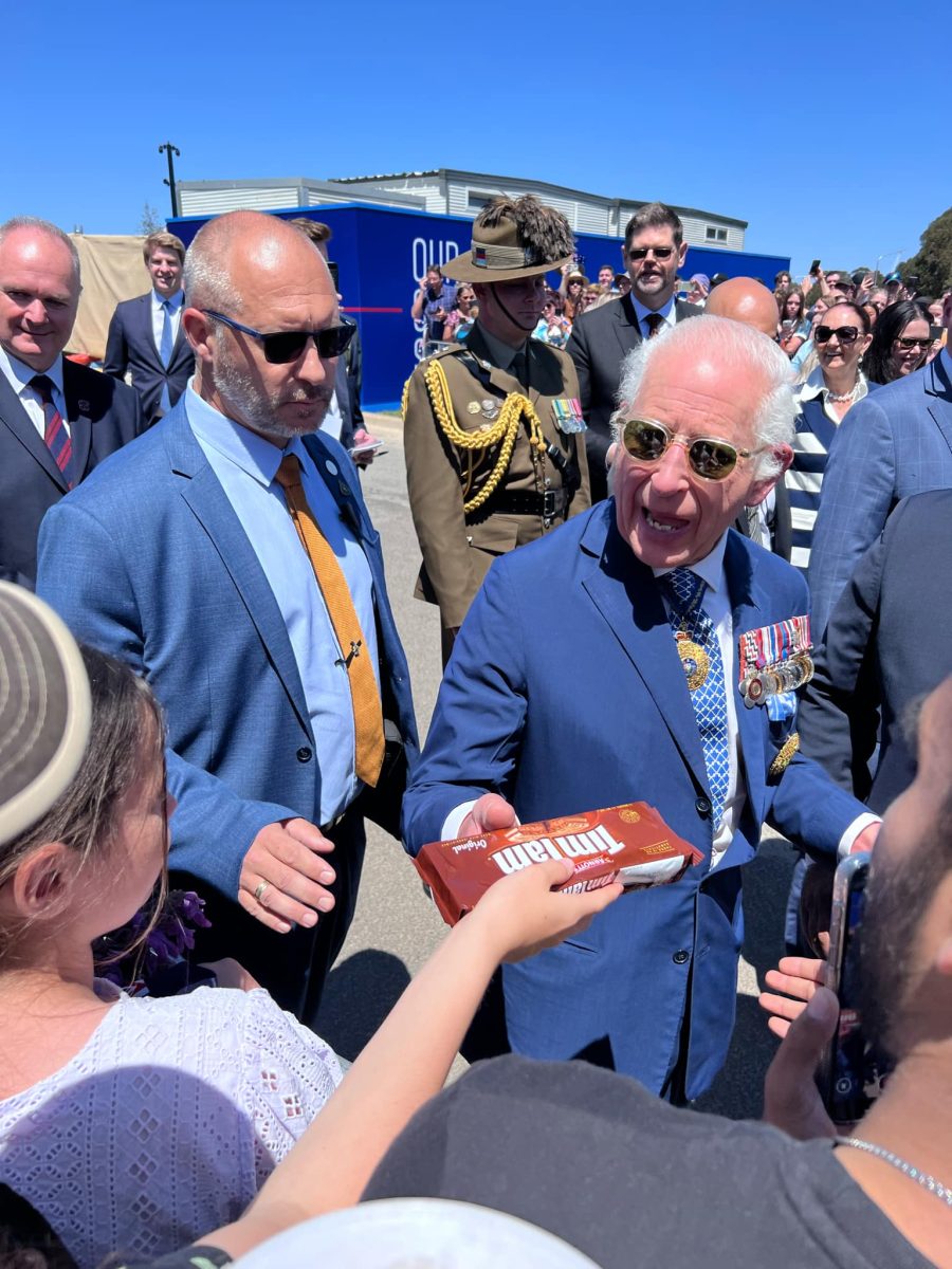 Ivan Pearce offers King Charles a packet of Tim Tams