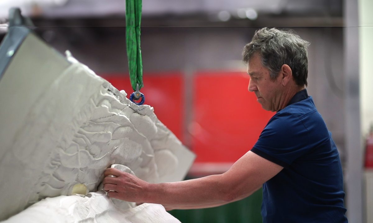 Artist Bruce Reynolds works on a large plaster relief