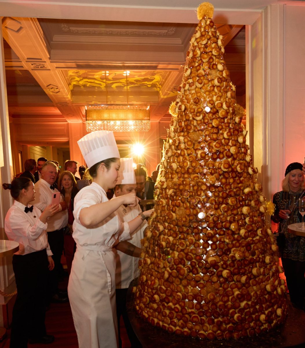 Chef standing next to dessert tower.