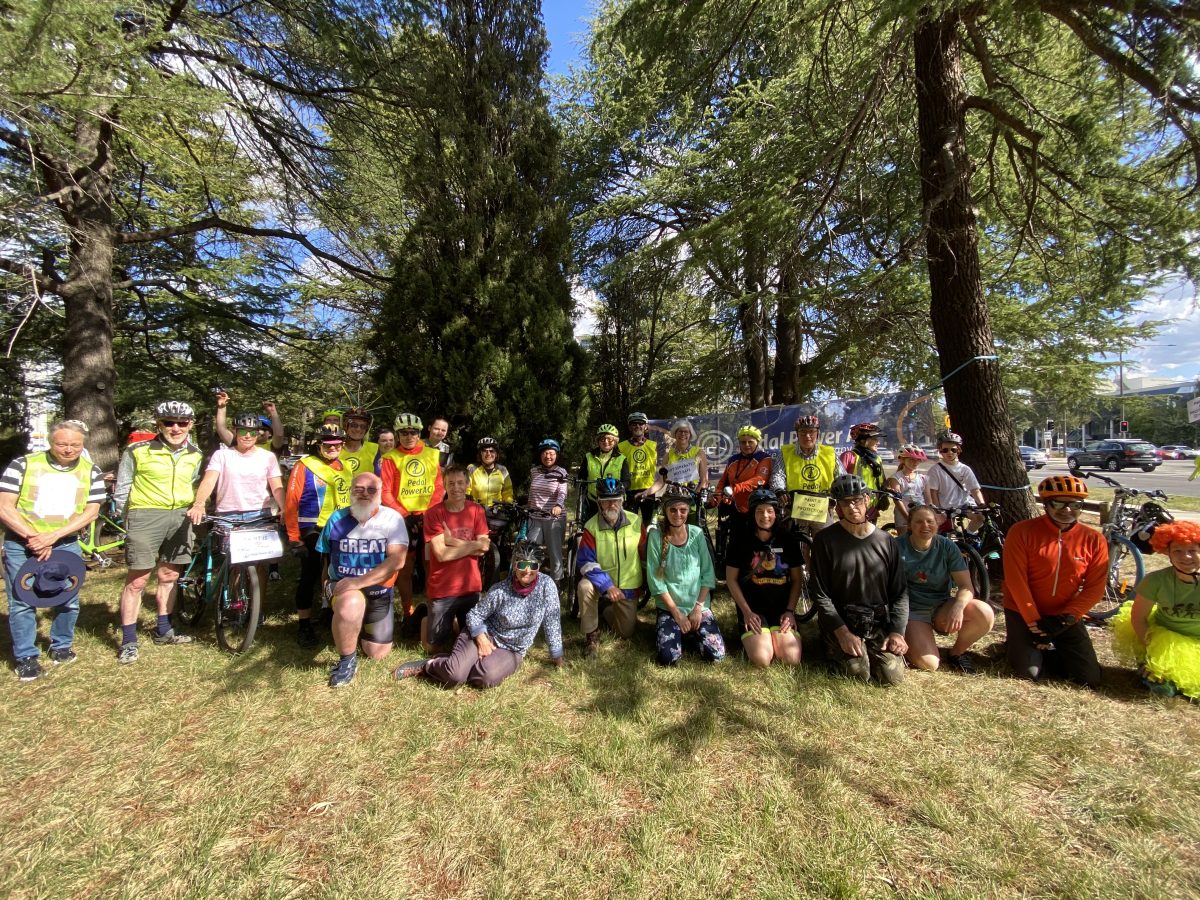 People with bikes wearing high vis gather in a group photo