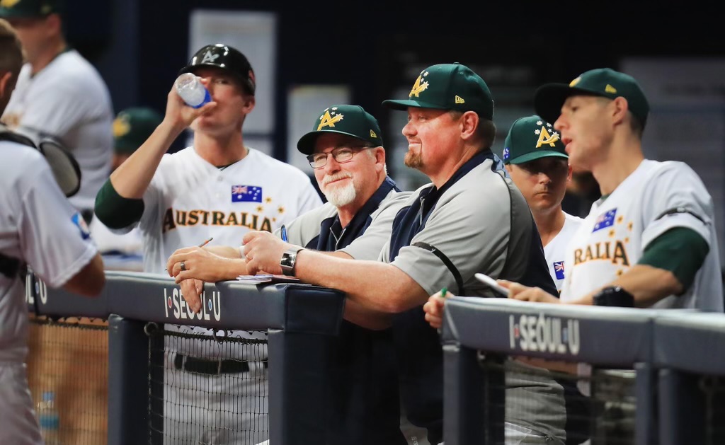 Jim Bennett amidst a group of baseball players in the dugout