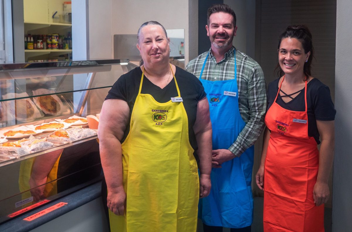 Canteens Area Supervisor Felicity Ayodele, Woden Community Service business performance manager Gavan Fairclough and Canteen Assistant at Alfred Deakin Ingrid Uelese on canteen duty at Alfred Deakin High School 