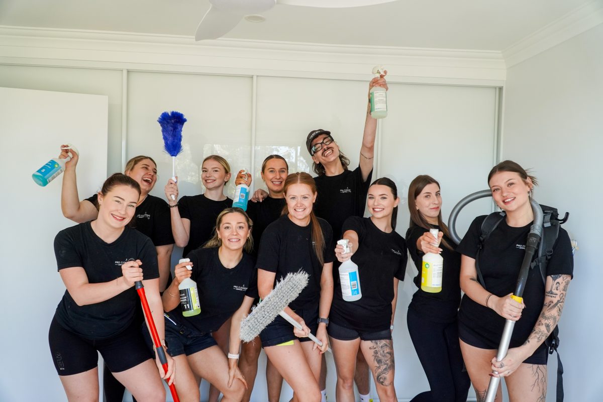 a group of people holding cleaning equipment in a room