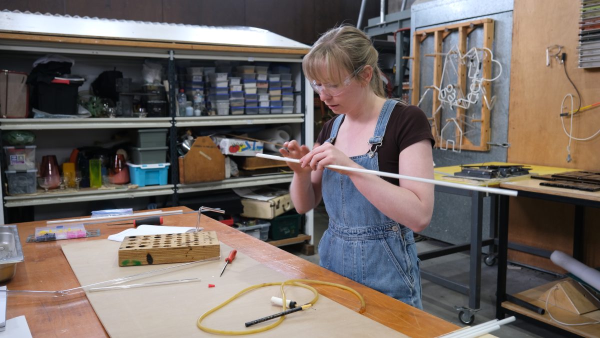 Sculptor Bronte Cormican-Jones working on neon light in a studio