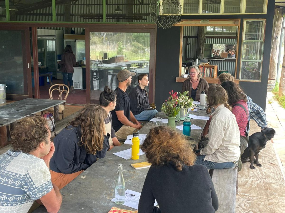 Group sits at a long table in discussion.