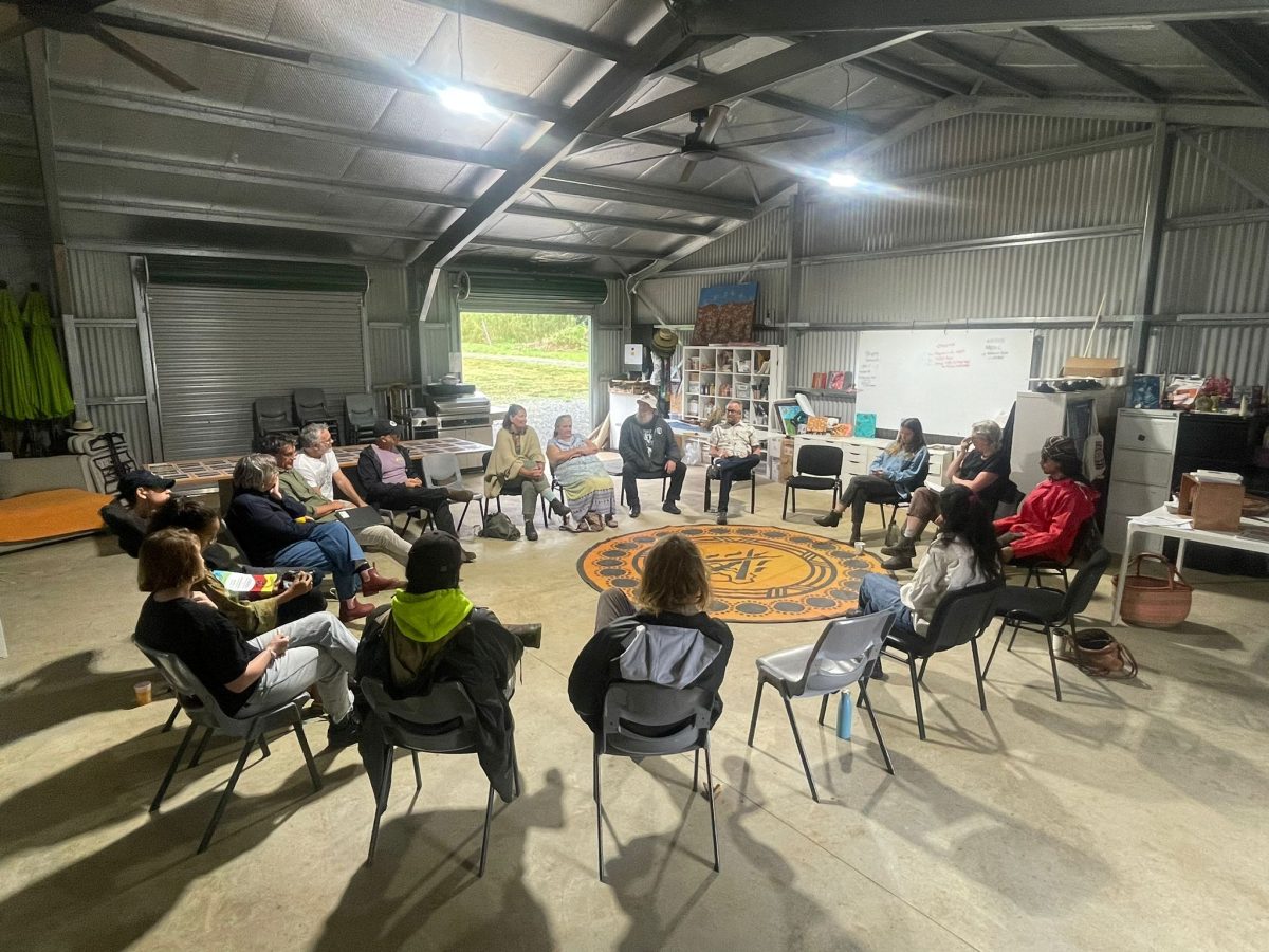 Group of people sit in a circle on chairs.