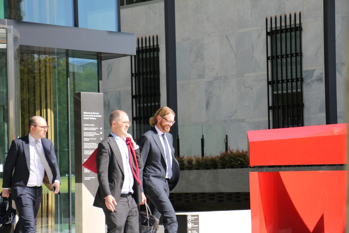 Three men in suits leaving court