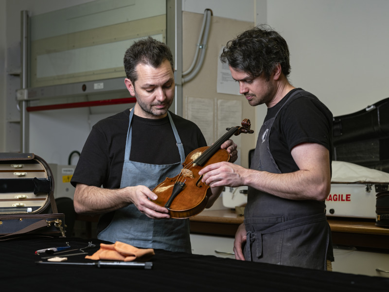 Luthiers Douglas and Max Glanville inspect a violin