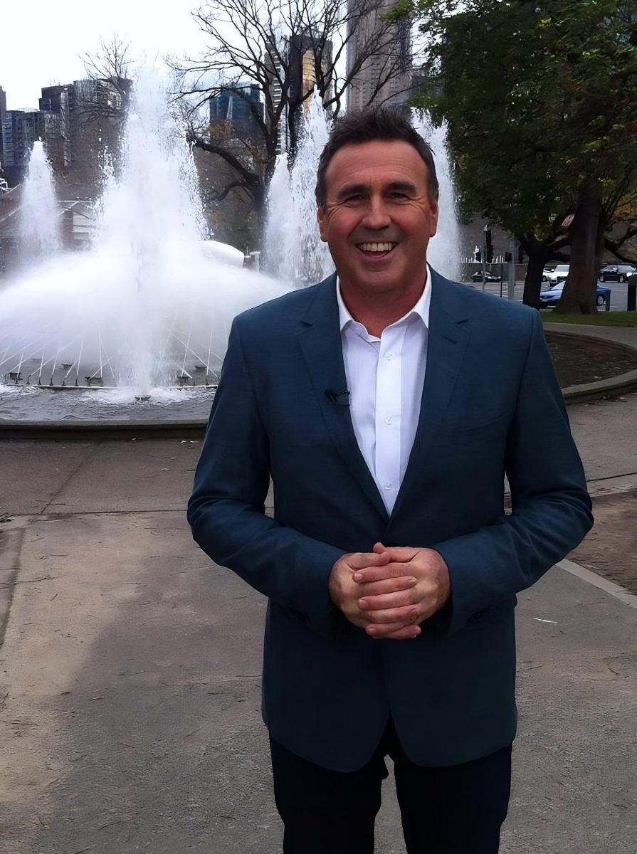 Smiling man standing in front of fountain 