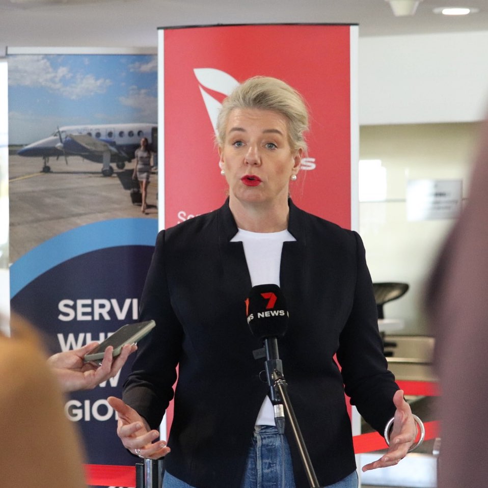 a woman giving a press conference at an airport