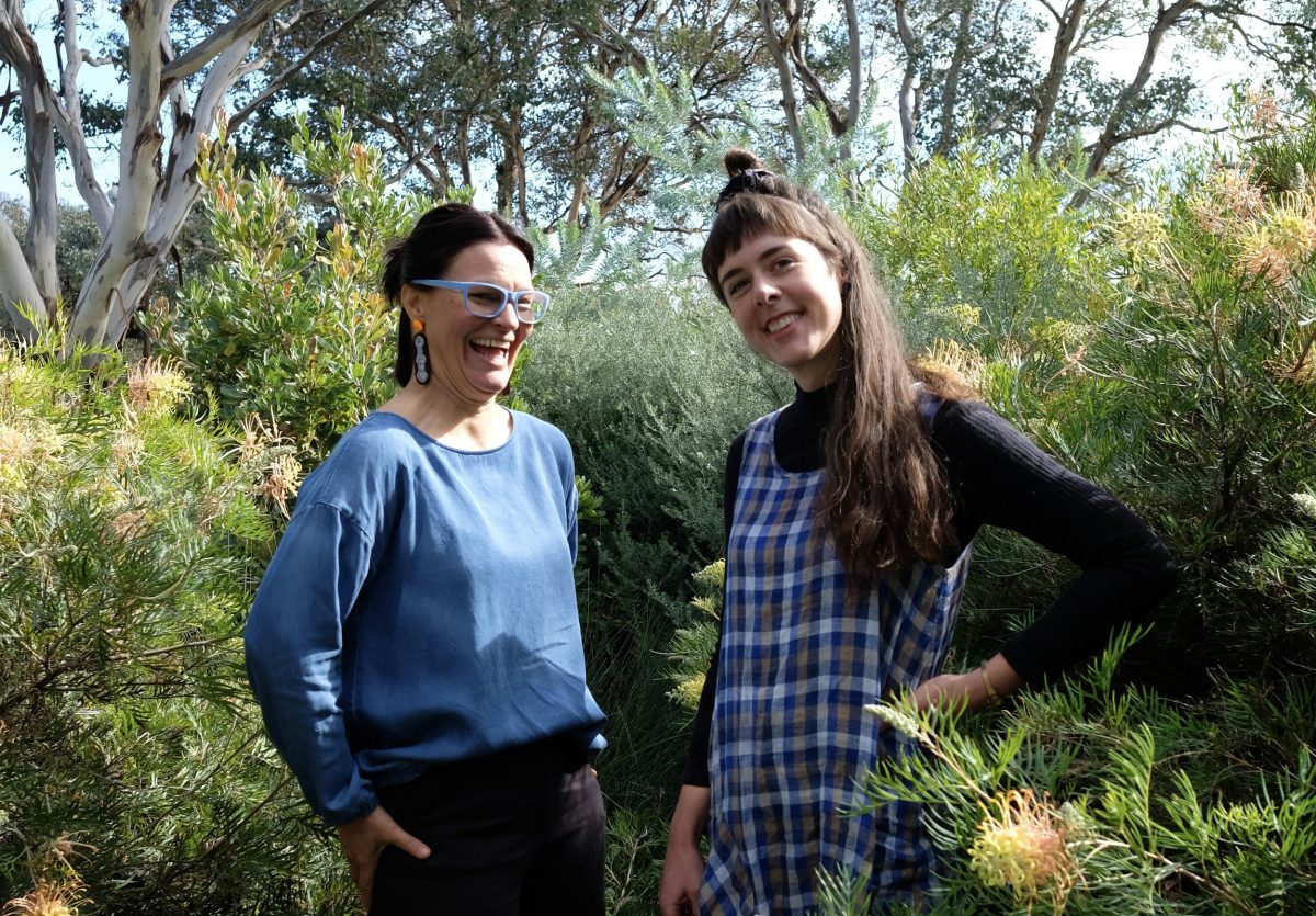 Podcast hosts Julie Bolton and Fiona Veikkanen stand smiling in a garden