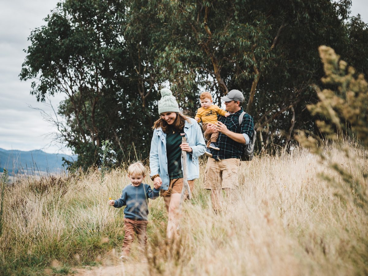 family walking through long grass in Ginninderry