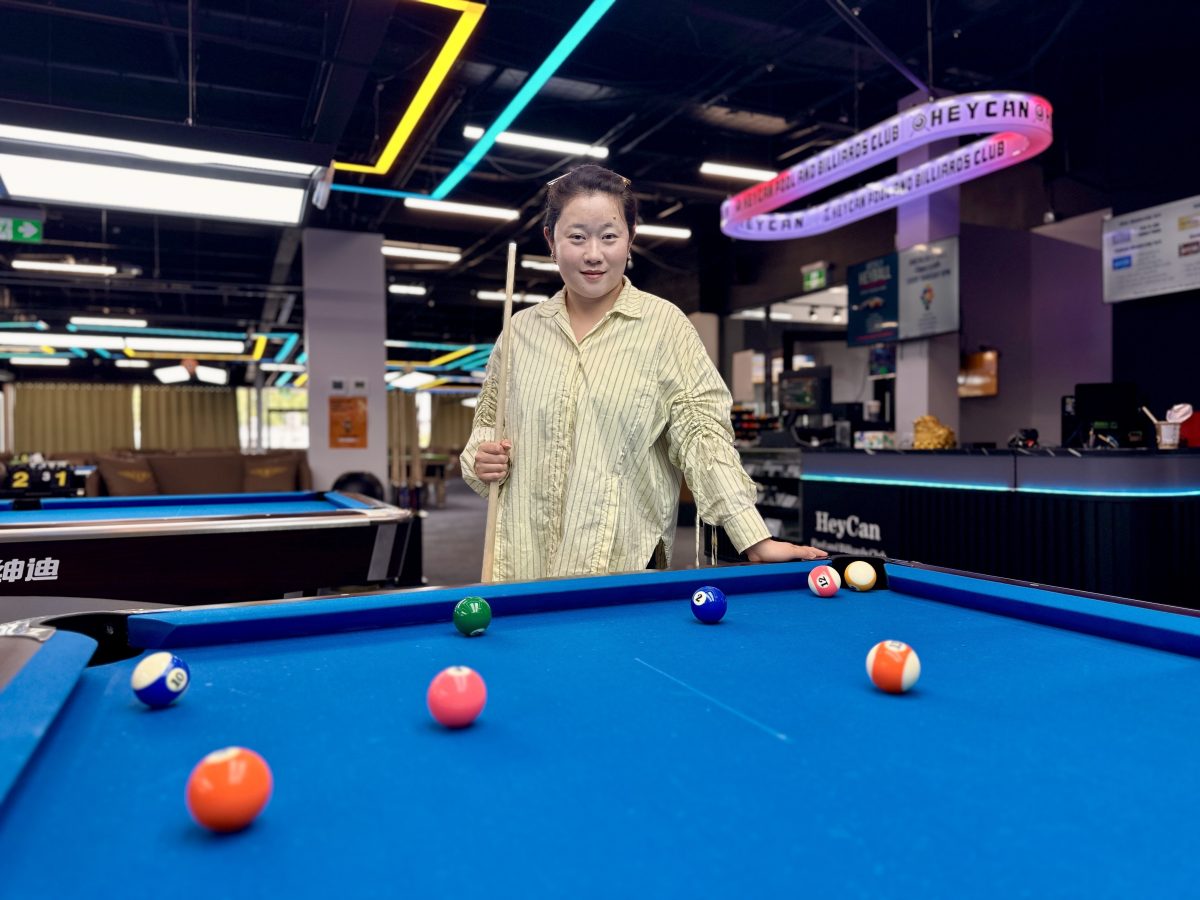 woman standing over a billiards table