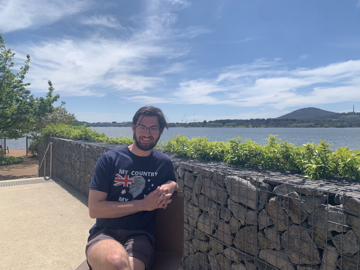 Matthew Stratton sitting in front of Lake Burley Griffin next to the Kingston foreshore.