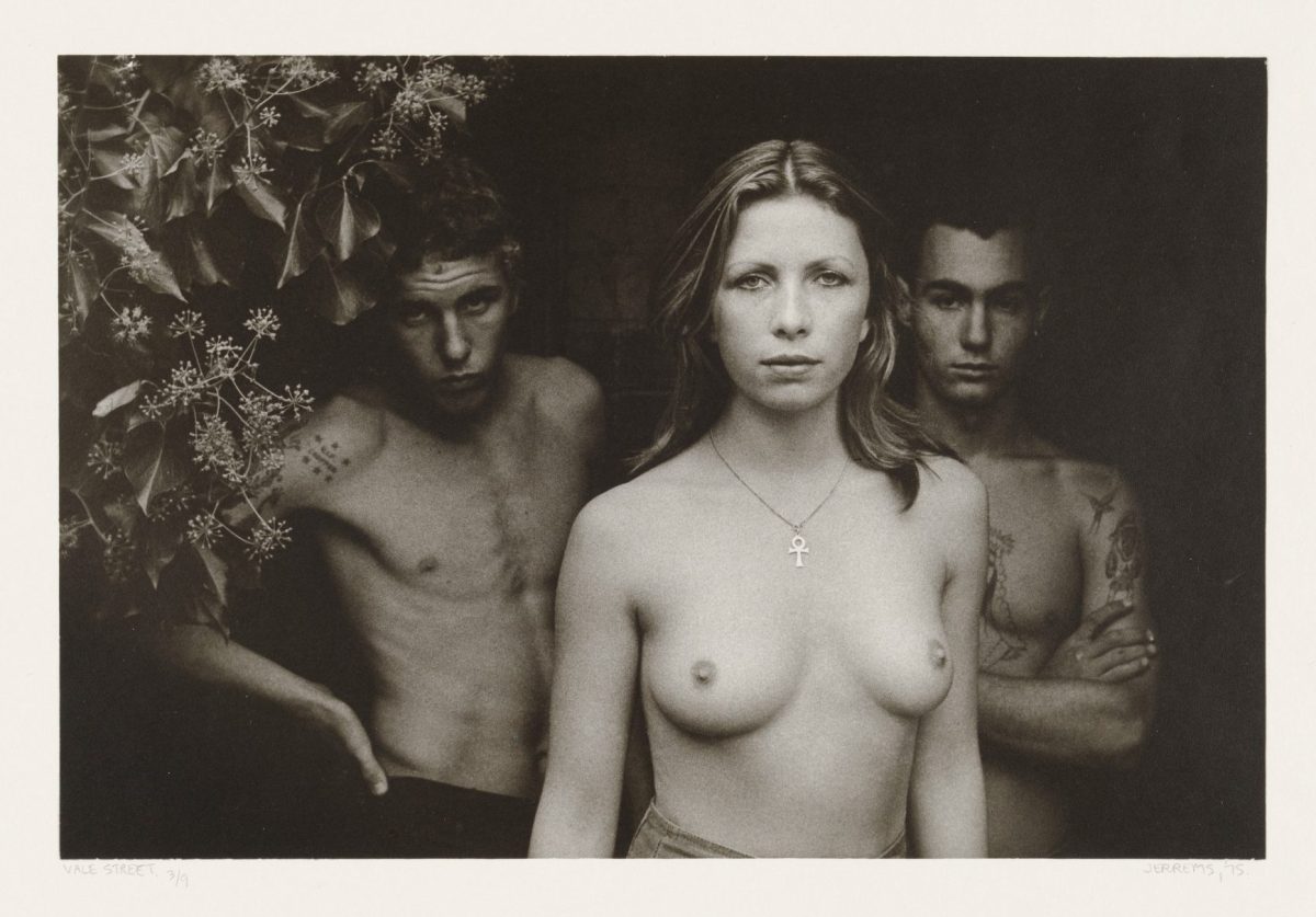 Three topless figures with a tree in the background