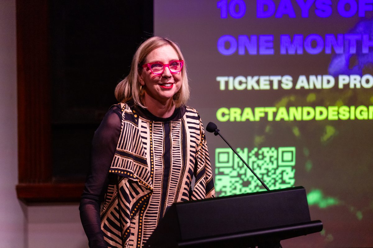 Woman with glasses behind microphone