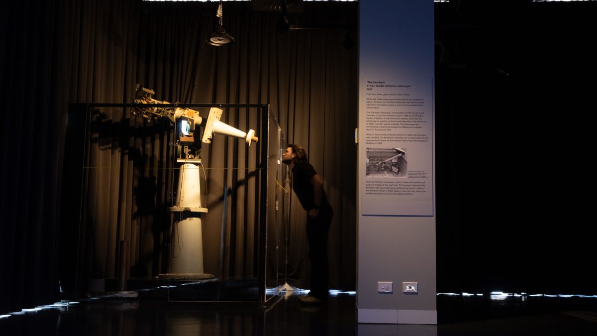 person looking at telescope