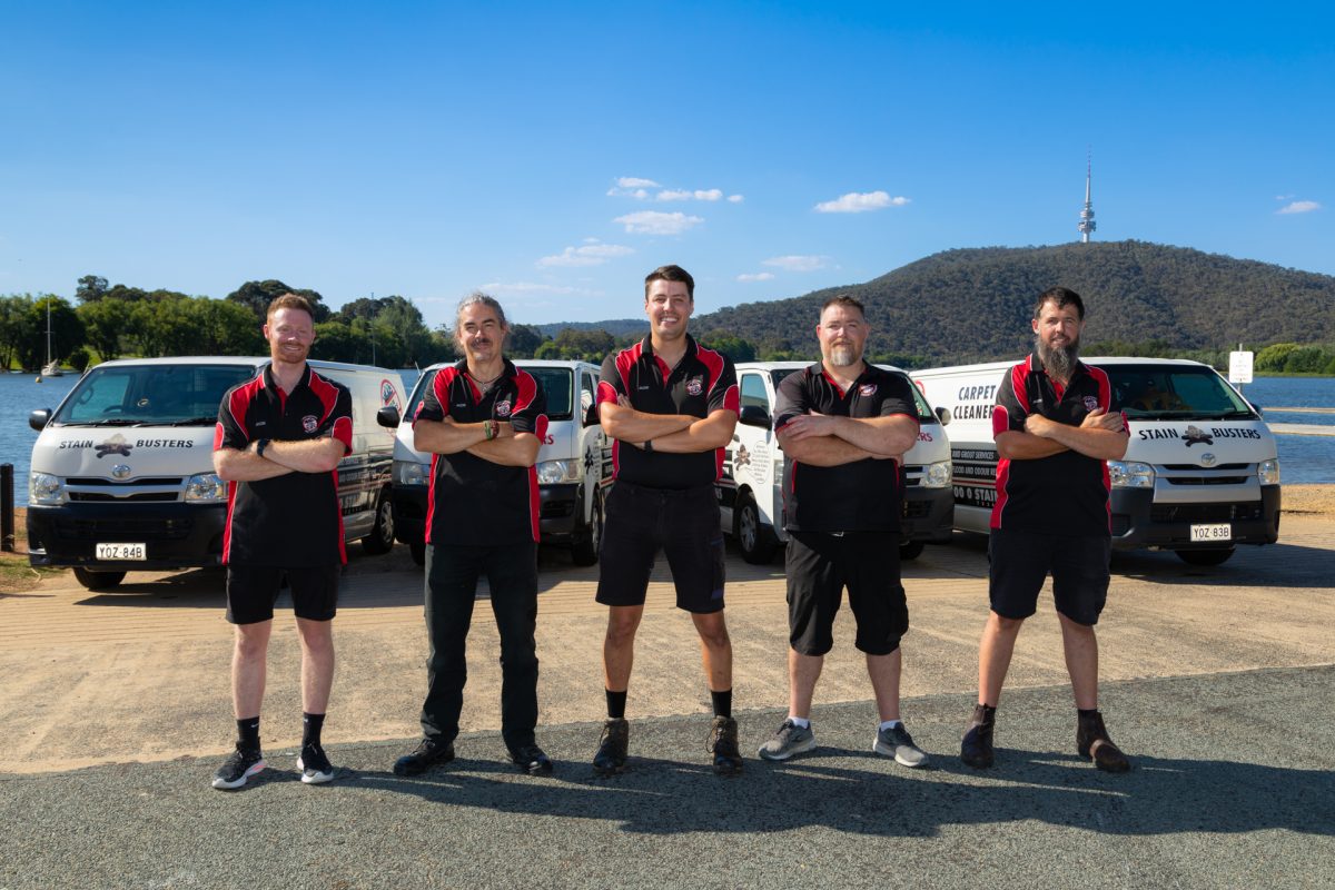 Five men standing next in front of 4 company vans at Lake Burley Griffin