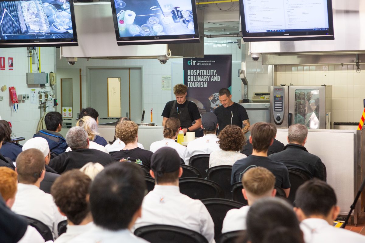 two people demonstrating a cooking class