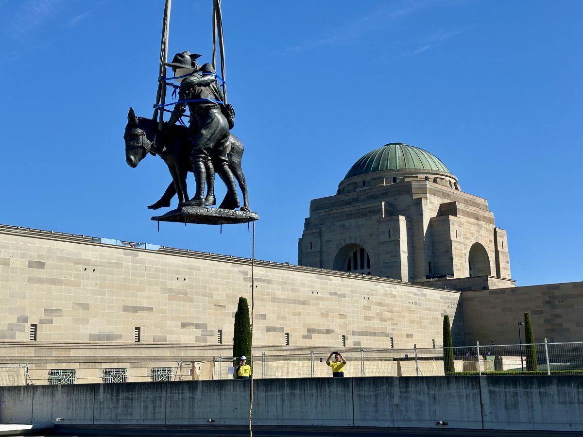 statue being lifted by a crane