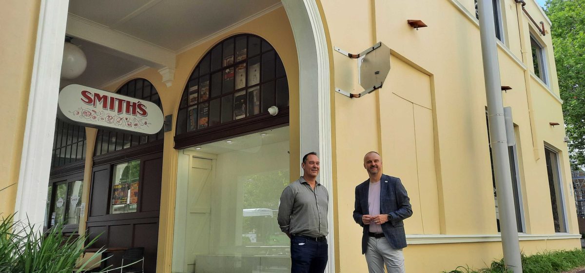 two men standing outside a historic building