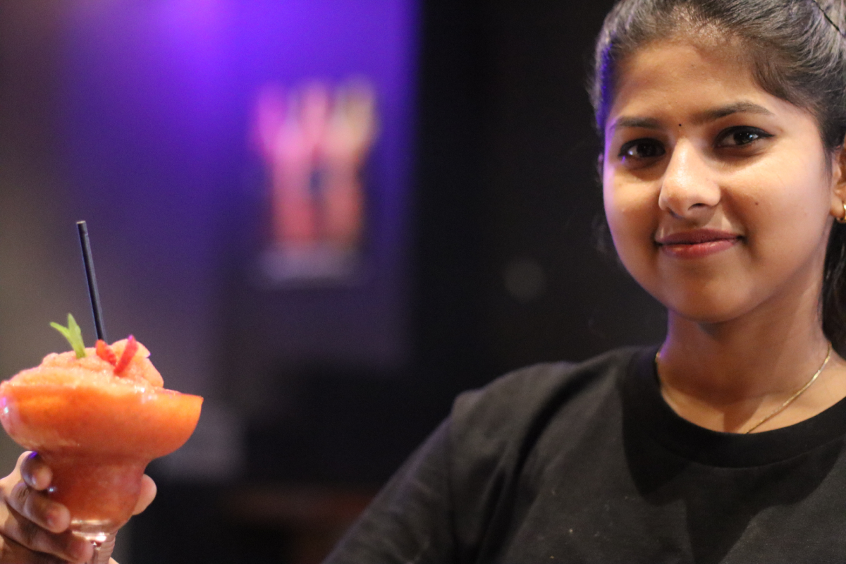 Woman holds cocktail.