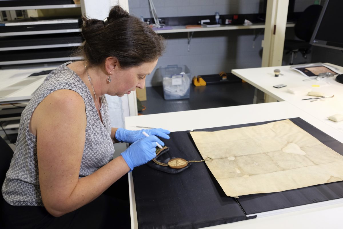 Conservator Libby Melzer works on old document