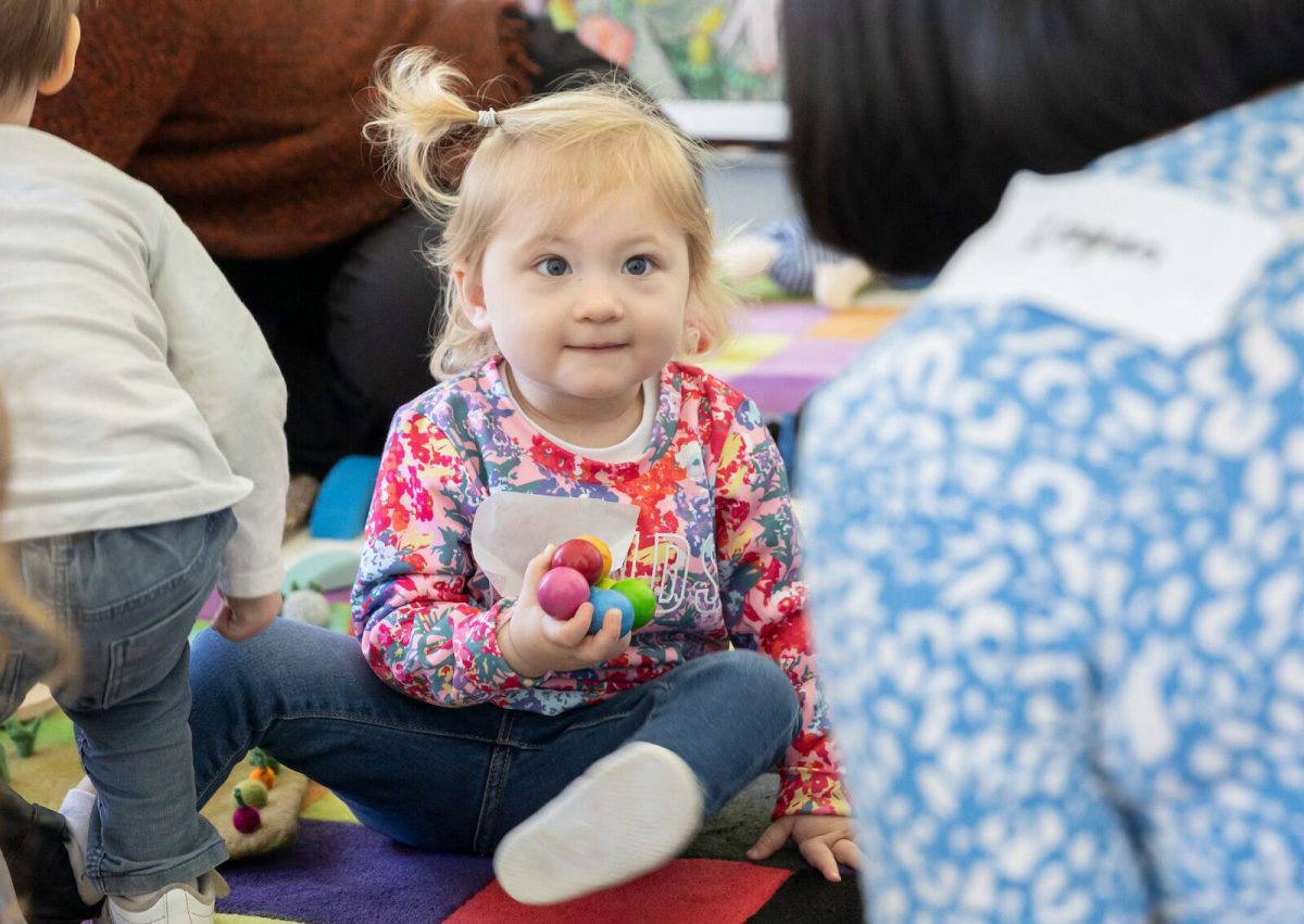 Blonde child holding colourful balls